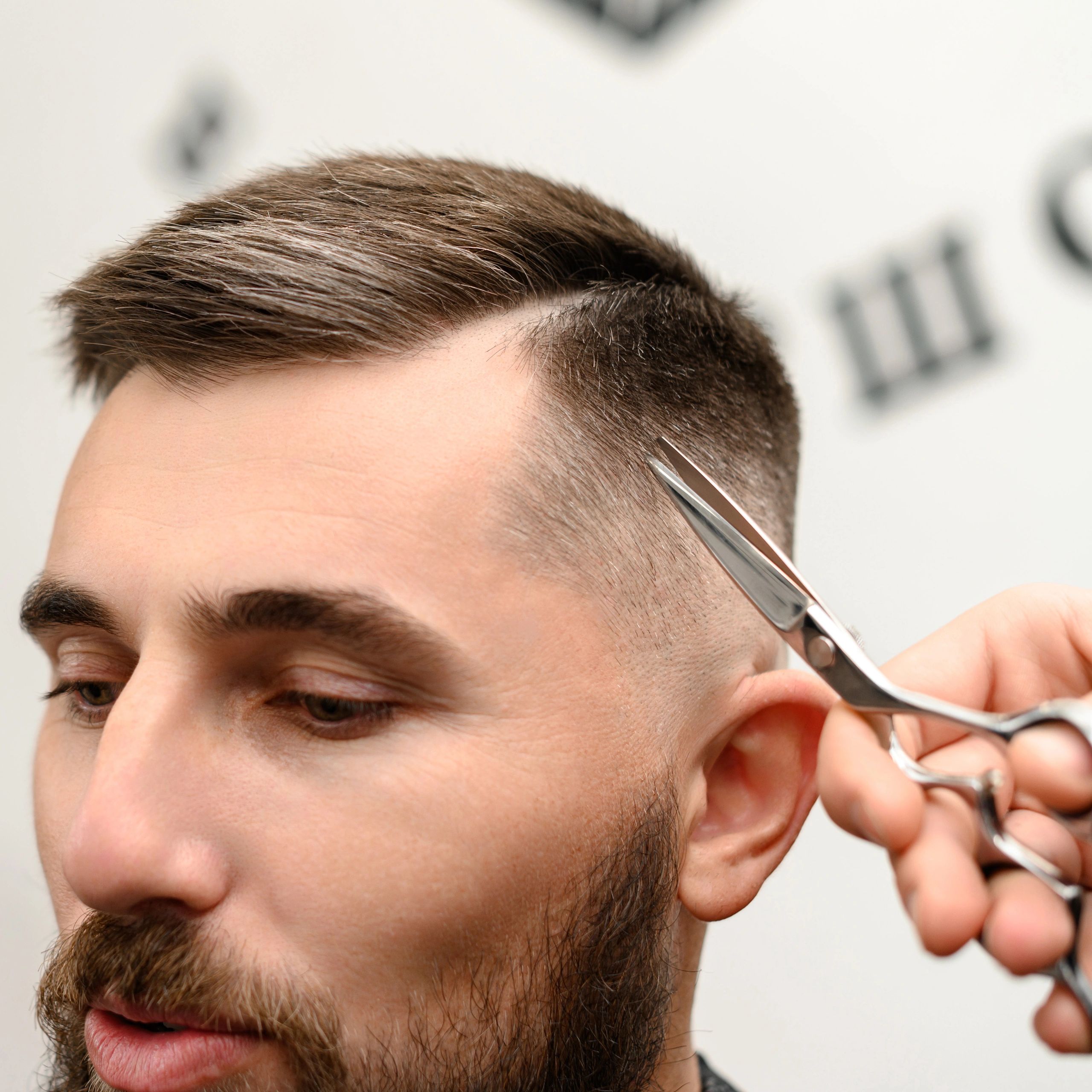 Barber shaping a fade haircut with scissors
