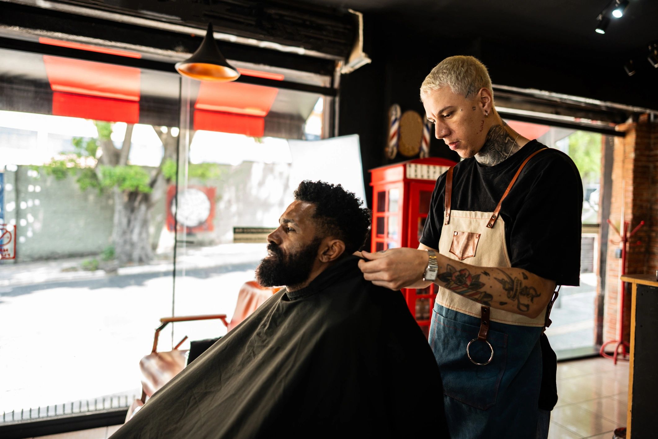 Barber placing a cape on a client before starting a haircut